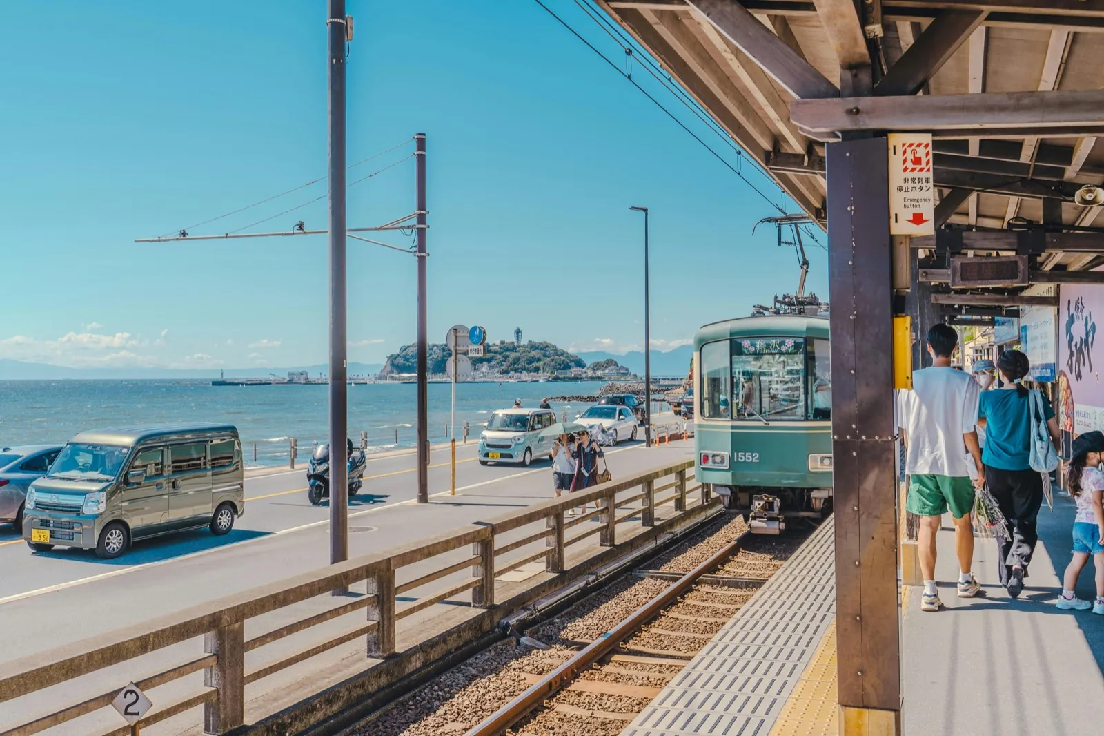 Enoden train by the sea with the island of Enoshima in the background in Kamakura