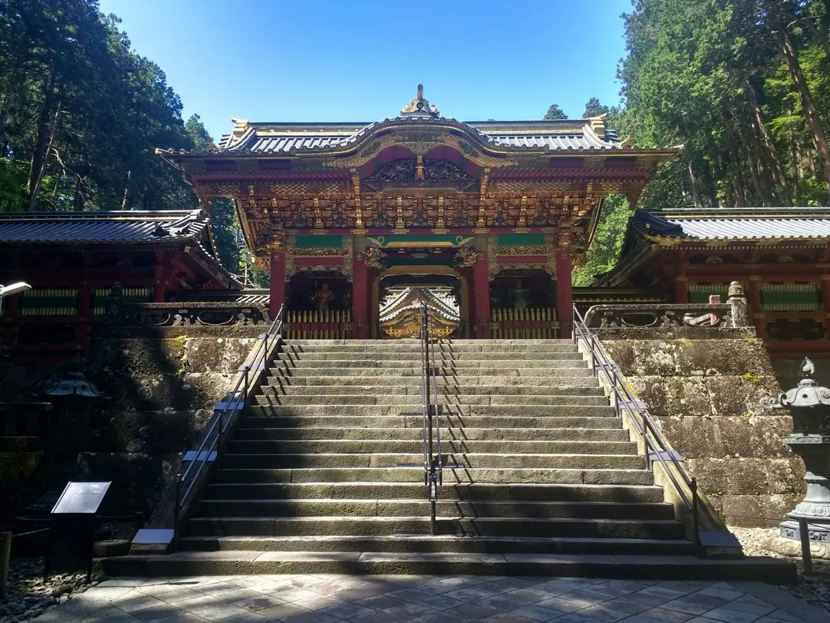 Ornate gate of the Nikko shrine complex among cedars